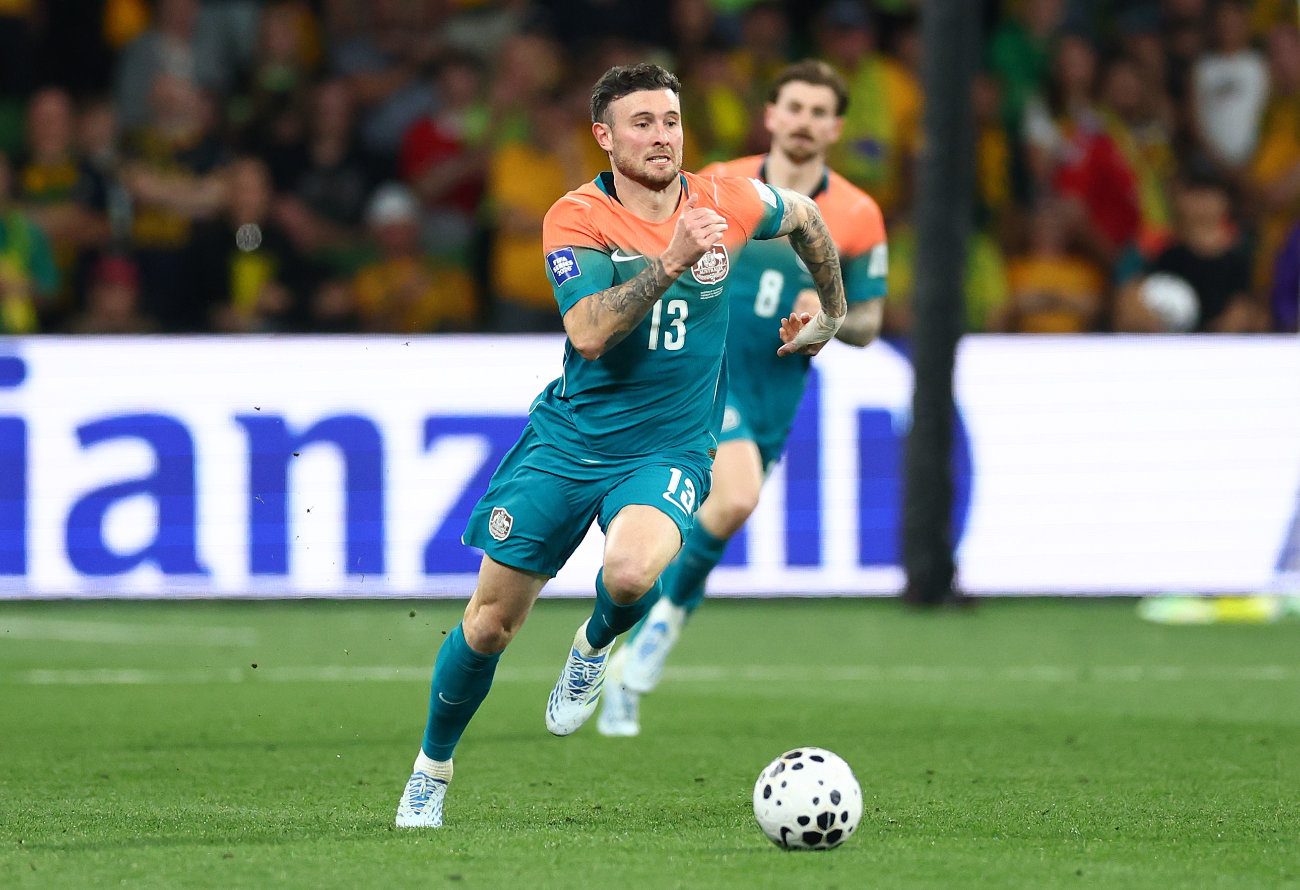O jogador do Socceroos, Aiden O'Neill, corre para perseguir a bola