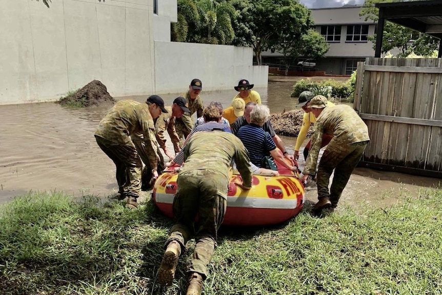 ADF soldiers and SES workers float out elderly residents from The Village at Yeronga retirement facility during floods.