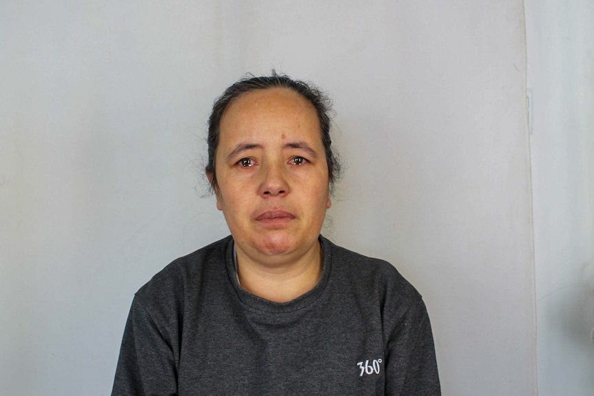 A photo of a woman who looks like she's about to cry in a police photo.