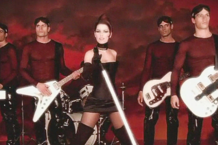 Shania Twain in the 'man i feel like a woman' video clip, dressed with men in tight red shirts