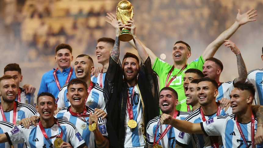 Argentina football team wearing medals with arms raised 