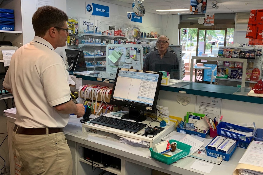 Rhys Jones attends to a customer in his pharmacy.