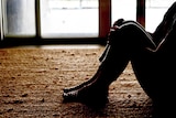 A woman sitting down in an empty room