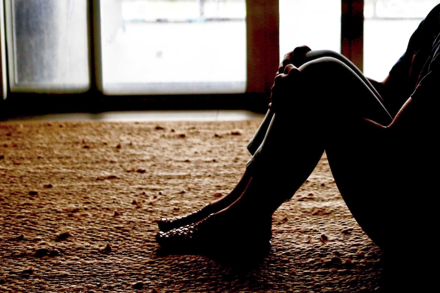 A woman sitting down in an empty room