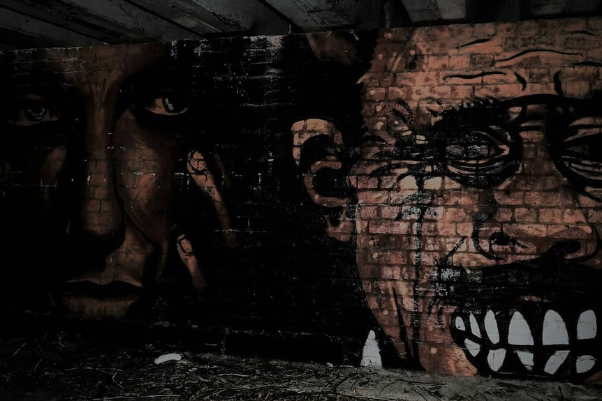 two faces painted on a brick wall.