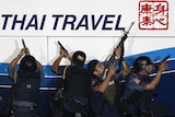 Police commandos aim their weapons as they surround a bus with tourists being held hostage