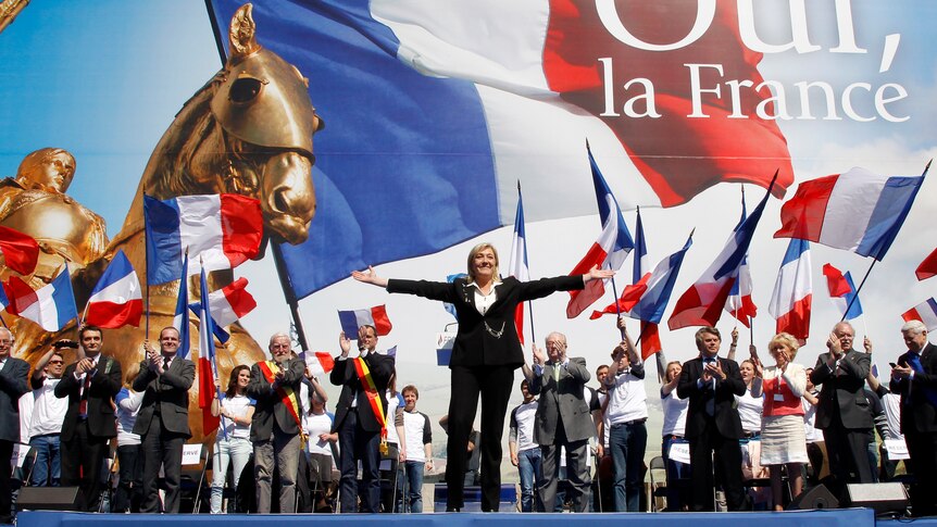 Marine Le Pen waves on stage in Paris