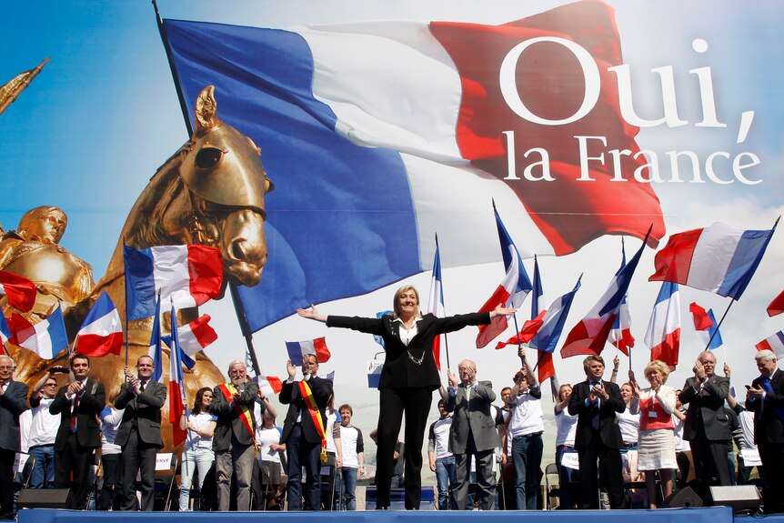 Marine Le Pen waves on stage in Paris