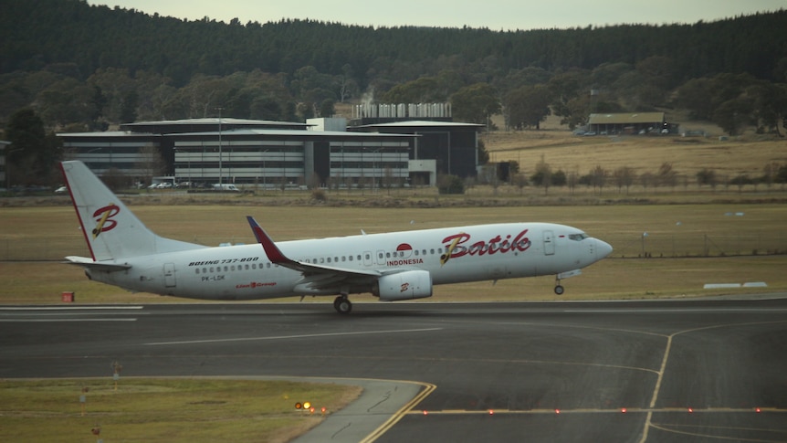 A plane with 'Batik' branding begins its take-off from the runway.