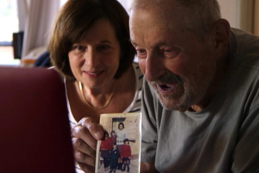 Aldo Boschin holds up a photograph during the Skype call to his daughter in America.