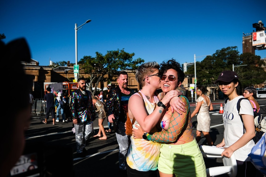 Woman kissing another woman on the street