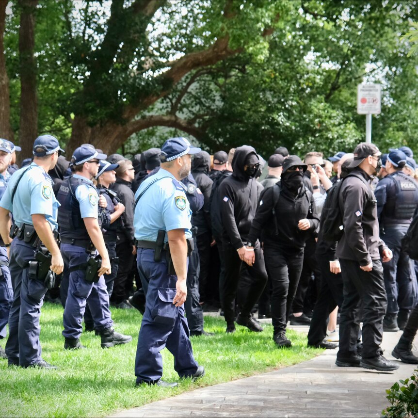 Men dressed in black including wearing balaclavas at North Sydney during police operation