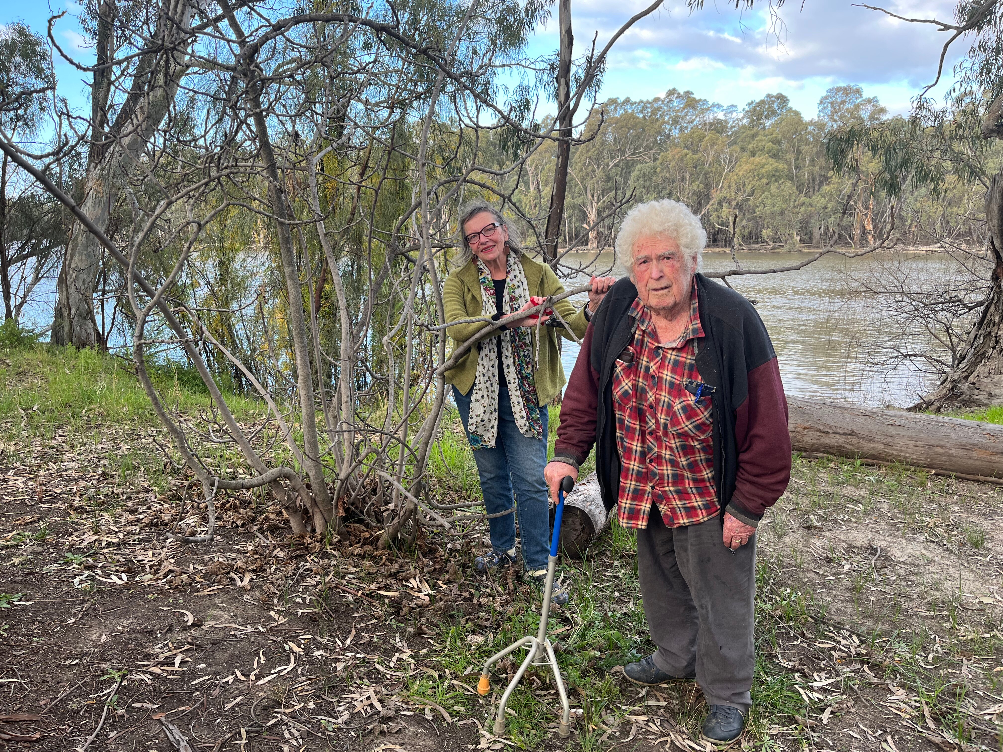 Yasmin Sadler and Mick Harding stand next to a dormant fig tree on the banks of the Murray River at Euston