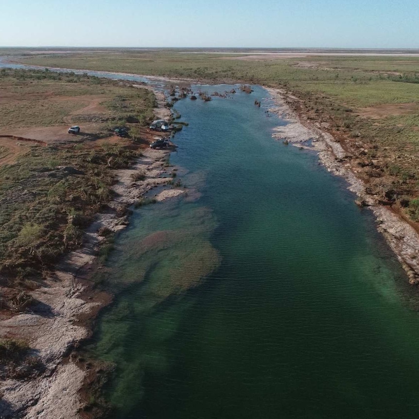 An aerial picture of a seemingly pristine waterway in an outback desert environment