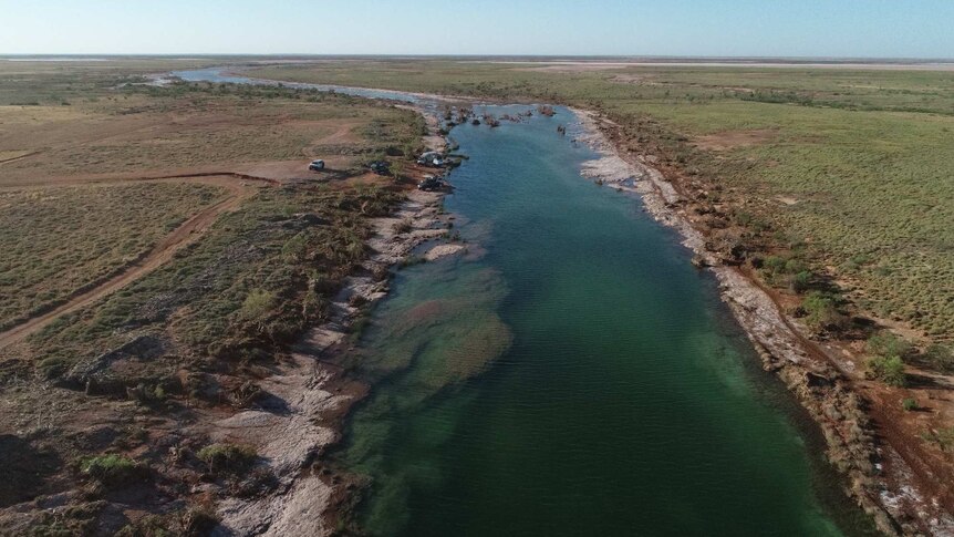 An aerial picture of a seemingly pristine waterway in an outback desert environment