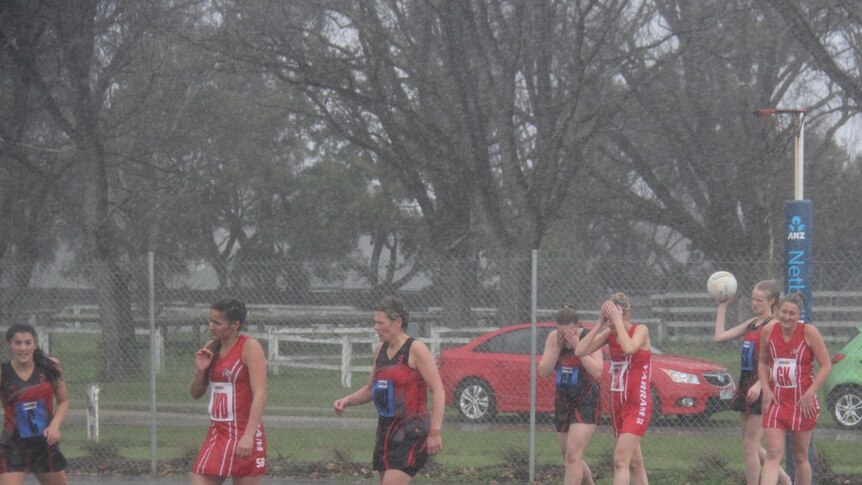 Yarram and Traralgon Tyers United play netball in wet and cold conditions.