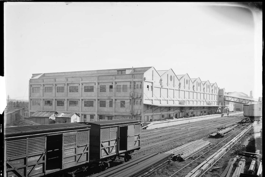 Black and white photo of the abattoir building with a train track in front of it