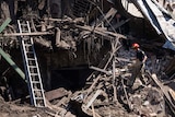 A fireman walks through the rubble of a destroyed building.