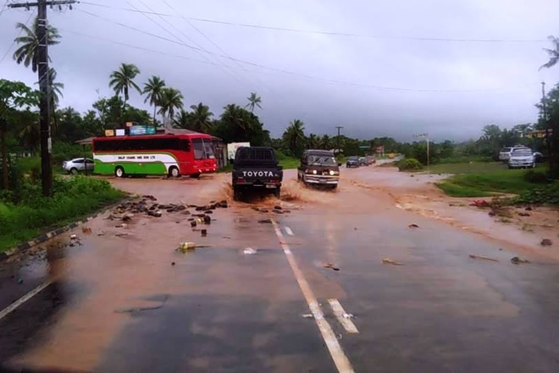Vehicles driving through a flooded road in Labasa in Fiji.