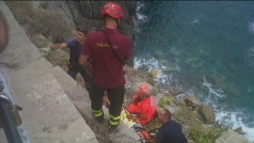 One of the trapped Australians is pulled to safety