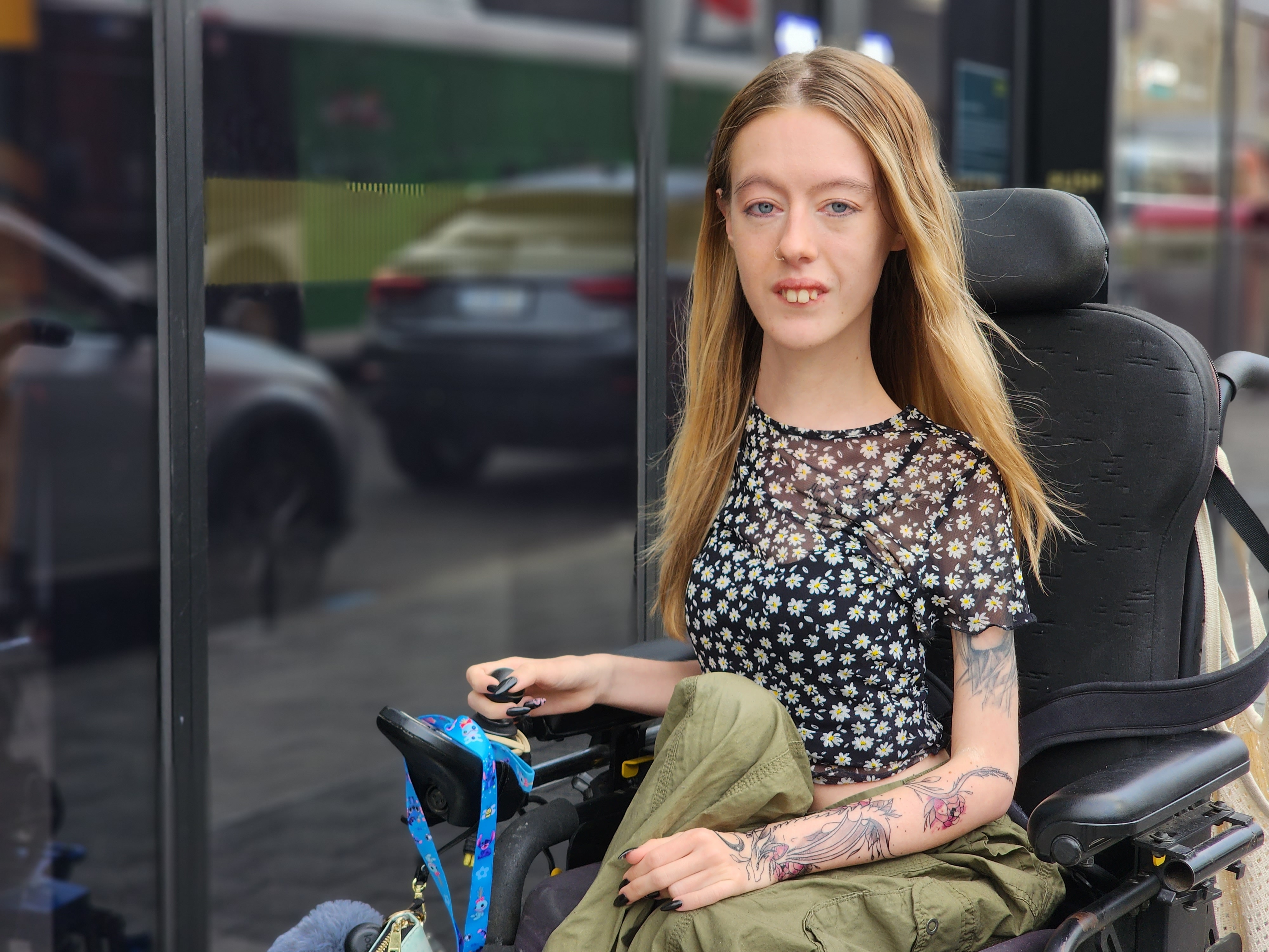 A young white woman in a wheelchair out on the street