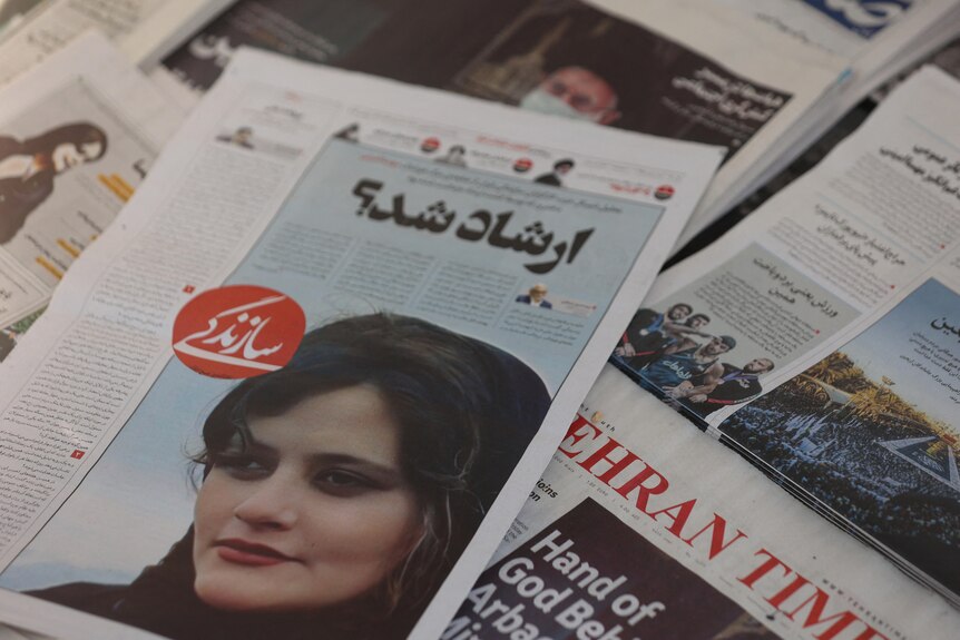 Newspapers showing face of young Iranian woman