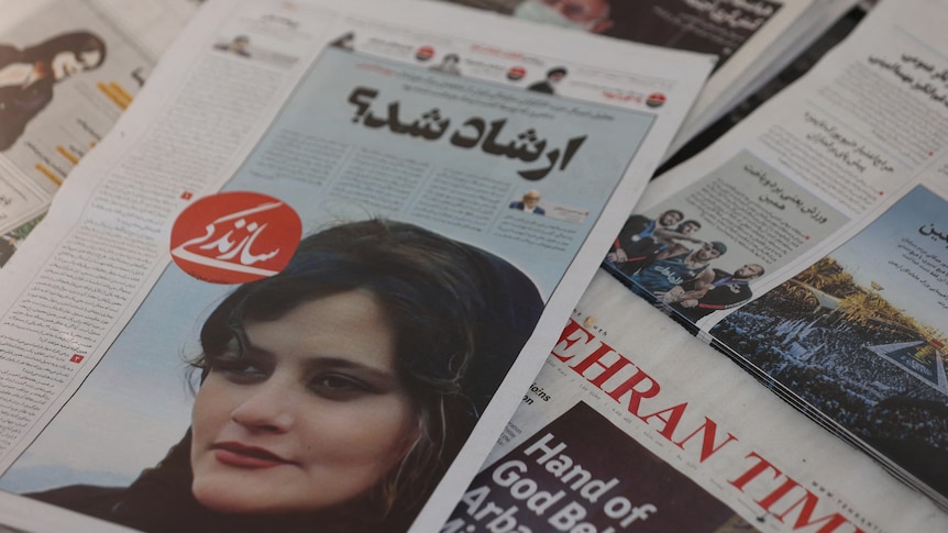 Newspapers showing face of young Iranian woman