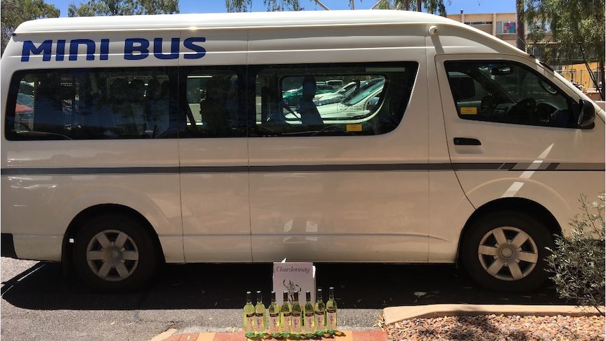 Eight bottles of chardonnay placed next to a taxi mini bus