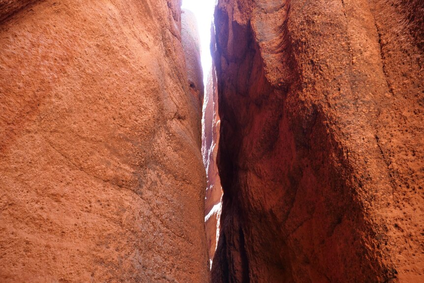 a light shaft penetrates a orange cliff chasm