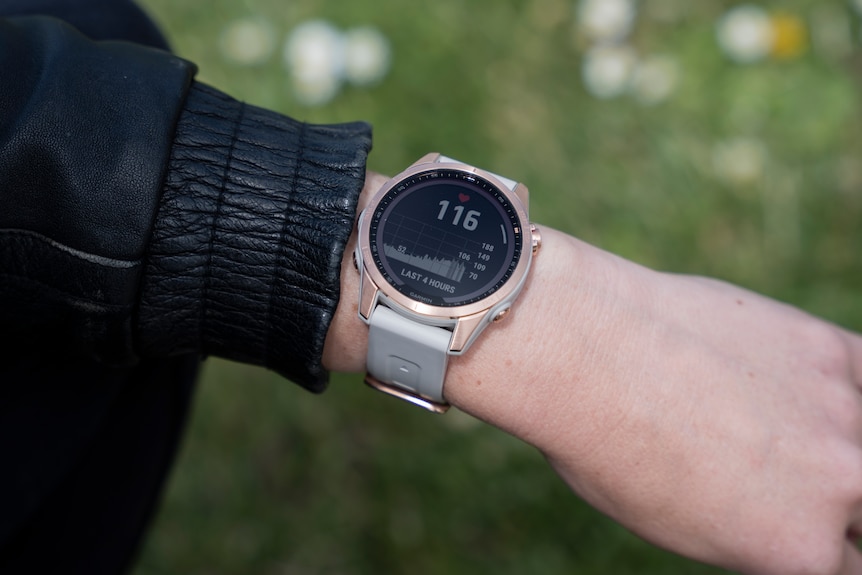 A close up of a heart rate monitor reading 116 on a woman's wrist