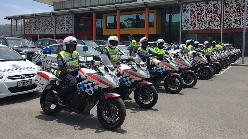 police on police motorbikes line up in a row outside a building