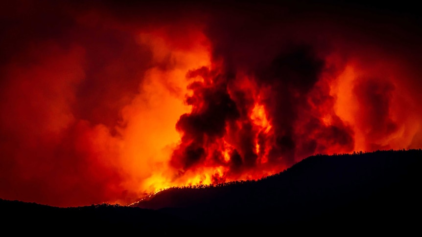 A fire burns beyond a mountain range in Namadgi National Park as seen from Mount Stromlo Observatory, January 28, 2020.