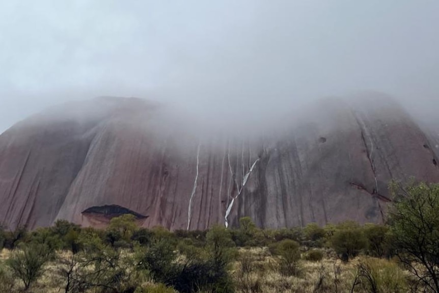 A low cloud hanging over Uluru in June 2023