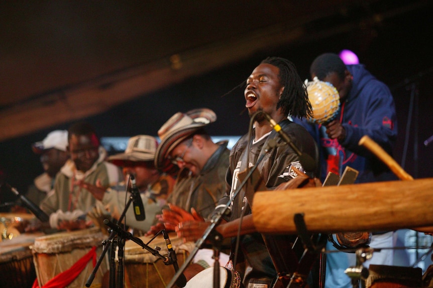 A group of musicians looking excited on a stage