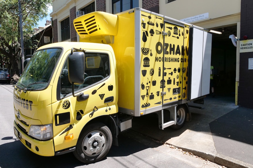 A bright yellow truck parked in the driveway of a garage