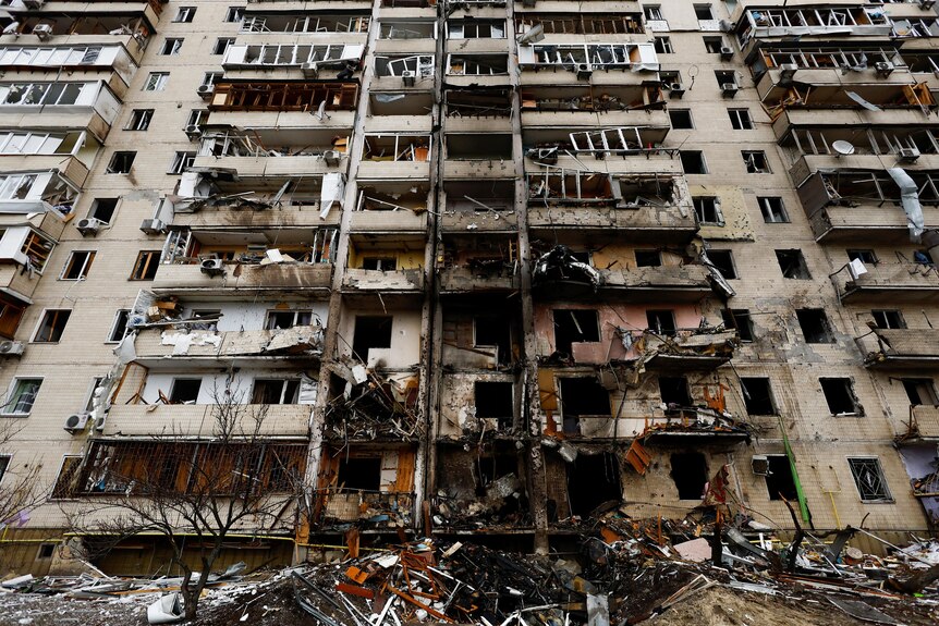a wide image of a seriously damaged building in ukraine taken from the ground looking up