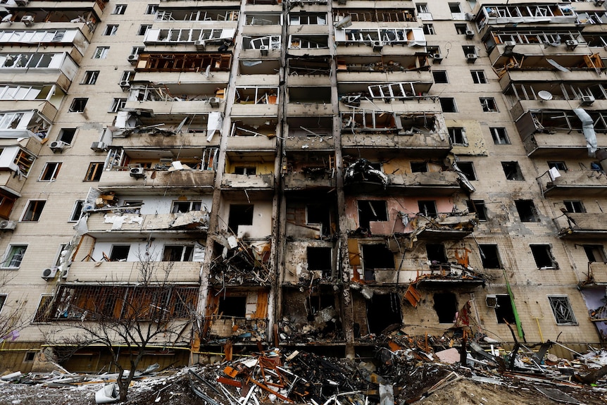 a wide image of a seriously damaged building in ukraine taken from the ground looking up