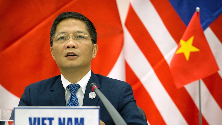 Vietnam's Trade Minister Tran Tuan Anh makes a speech at a lectern.