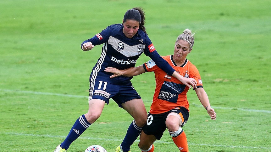 Two players contest for the ball in a W-League soccer game.