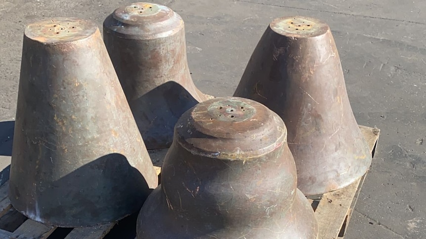 Four large bells sitting on a pellet