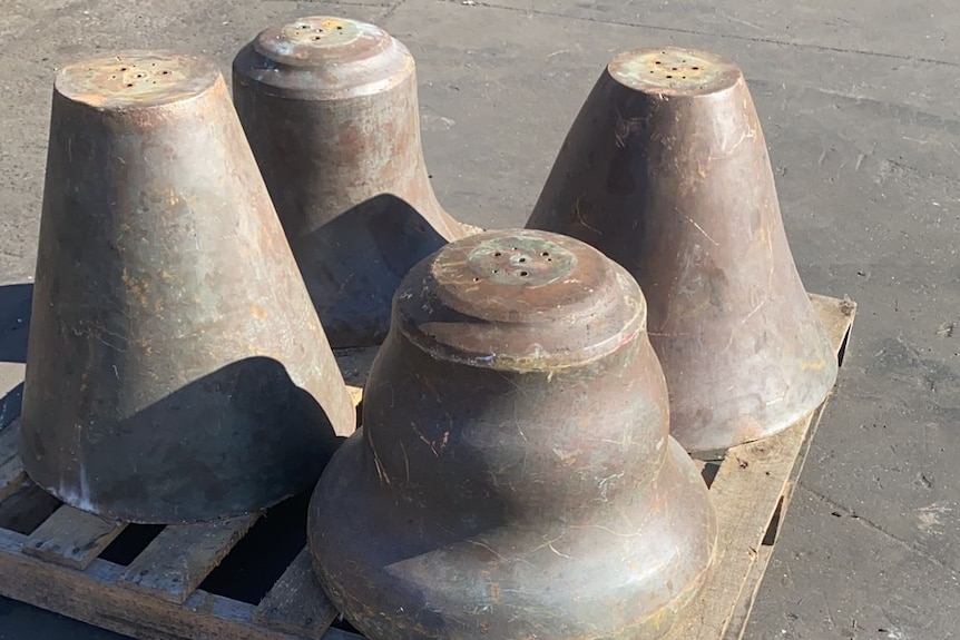 Four large bells sitting on a pellet