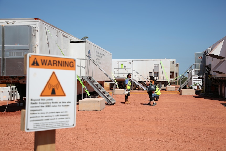 Dongas are set up with NASA branding on red dirt with a blue sky in the background.