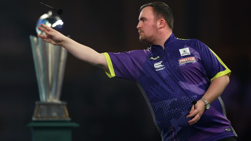 Luke Littler throws a dart with his right hand during the World Darts Championship final.