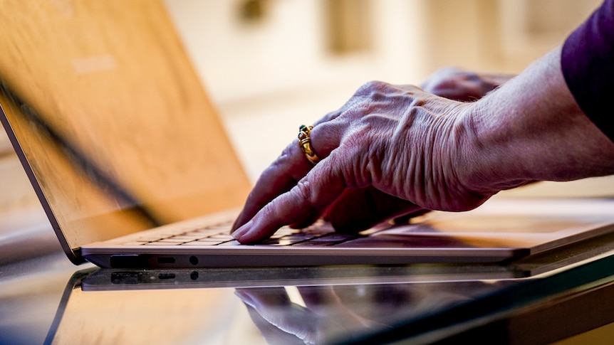 elderly hands using a laptop