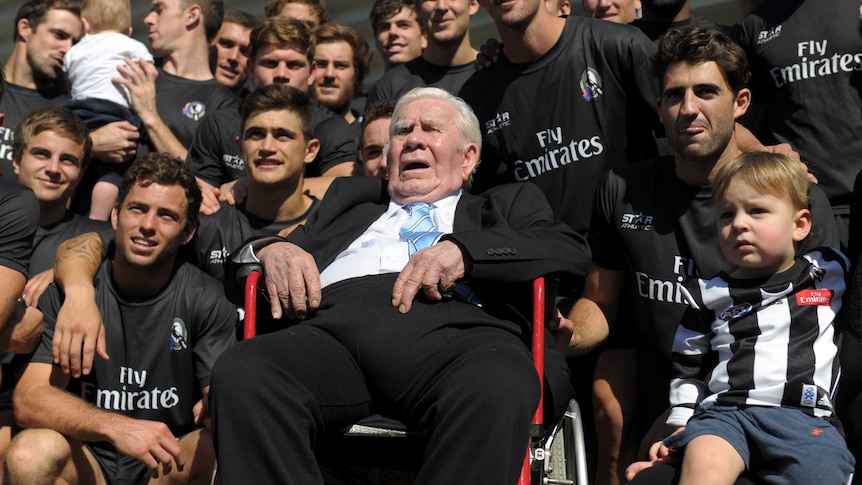 Lou Richards poses with Collingwood players and fans