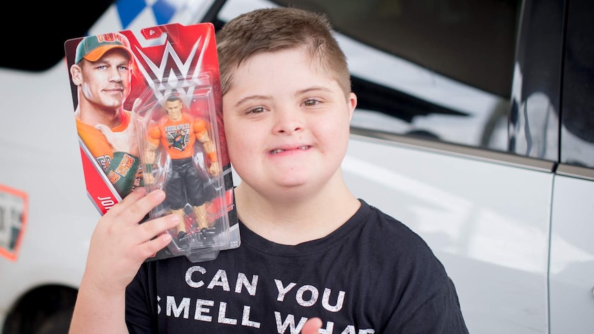 Jesse Fullerton gives a thumbs up as he holds on to a brand new wrestling figurine donated by toy manufacturer Mattel.
