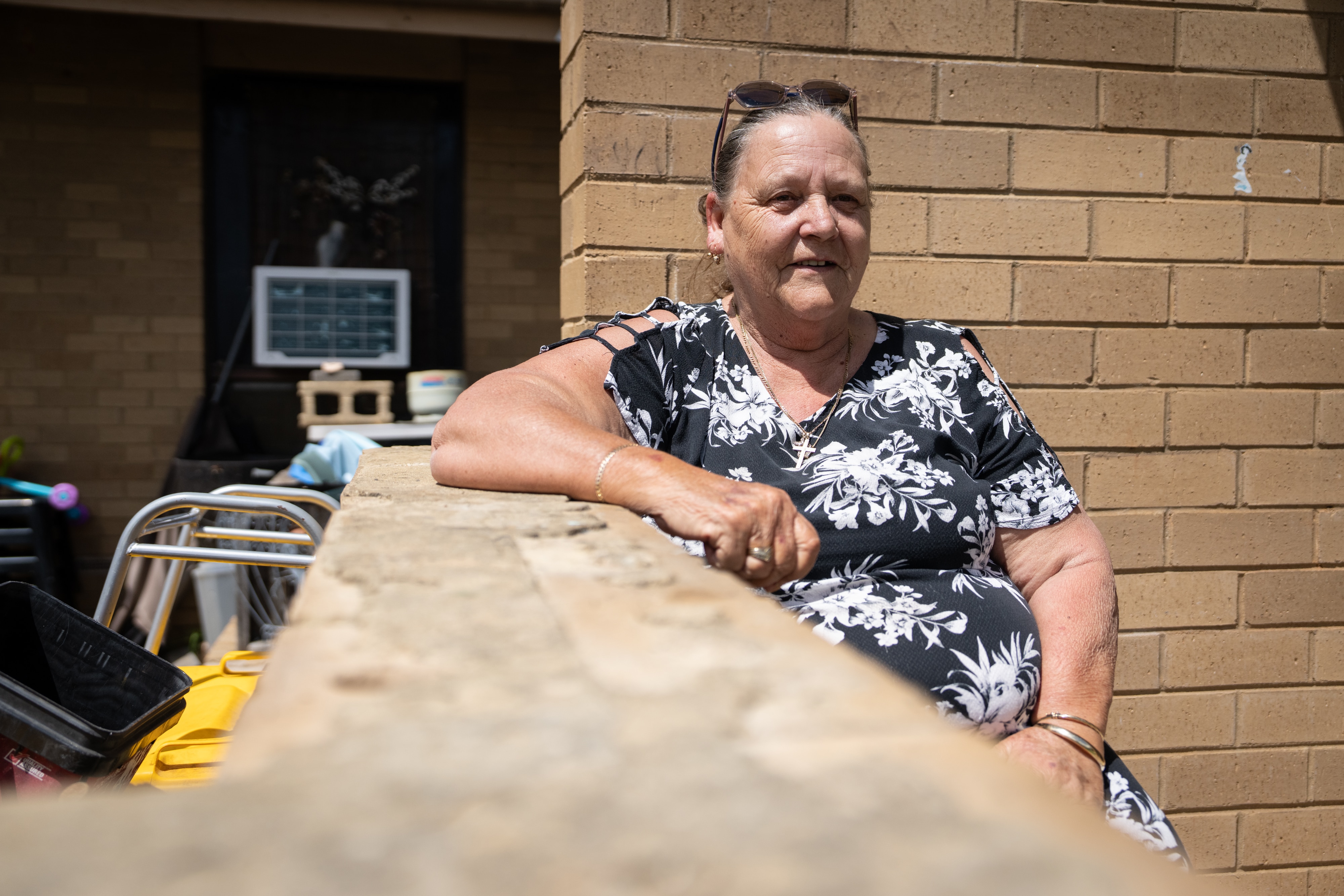 A woman sits on her front porch