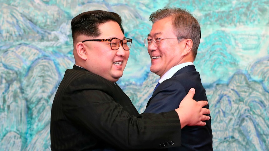 Kim Jong-un and Moon Jae-in hug.