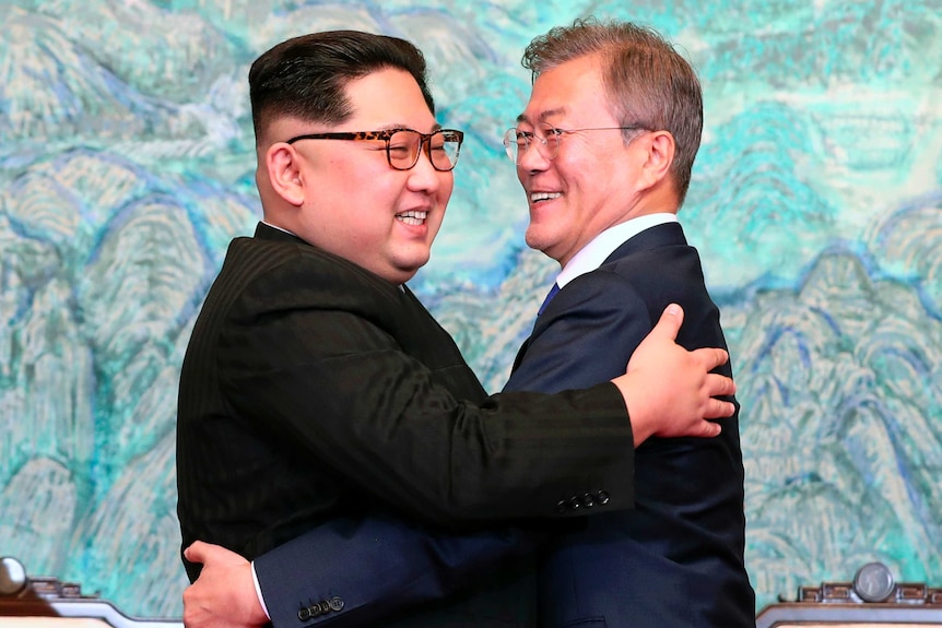 Kim Jong-un and Moon Jae-in hug.