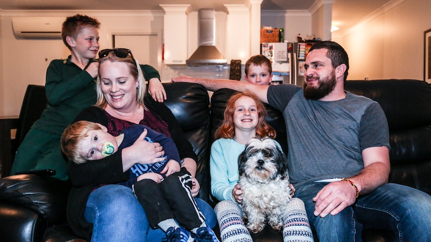 Suzie Oogjes (left) with her partner Yorta Yorta man Simon Penrose (right) with their children all sitting on the couch.